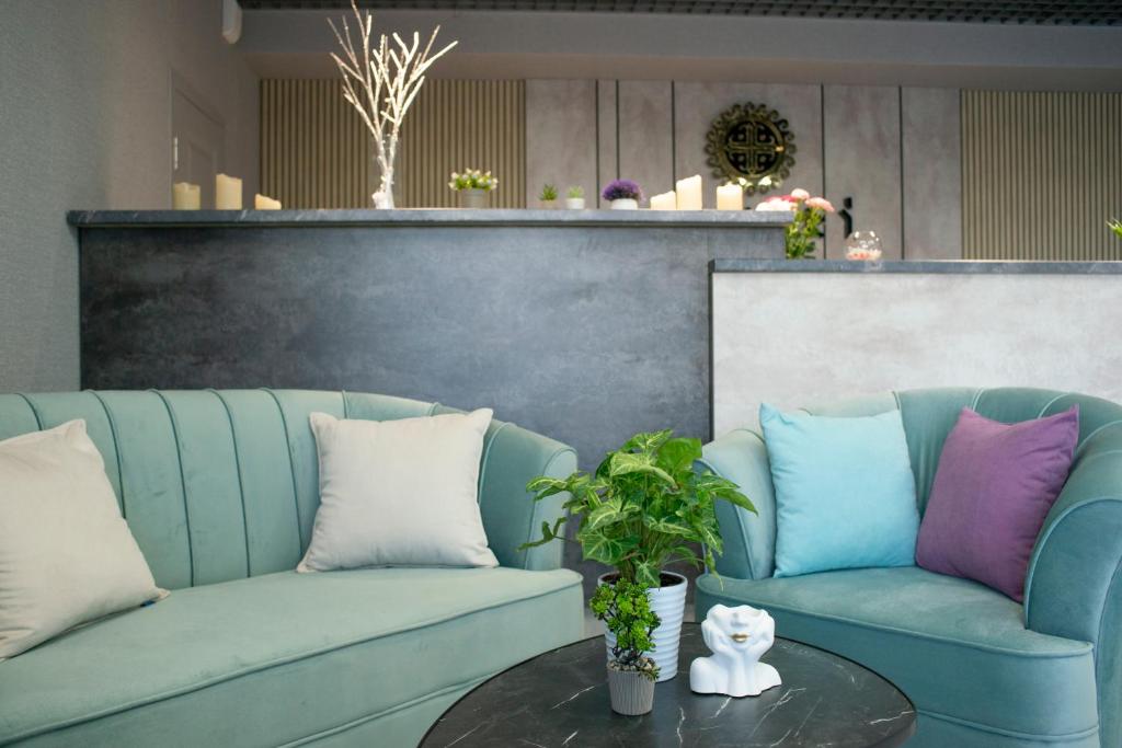uma sala de estar com dois sofás azuis e uma mesa em Tengri Hotel em Aktau