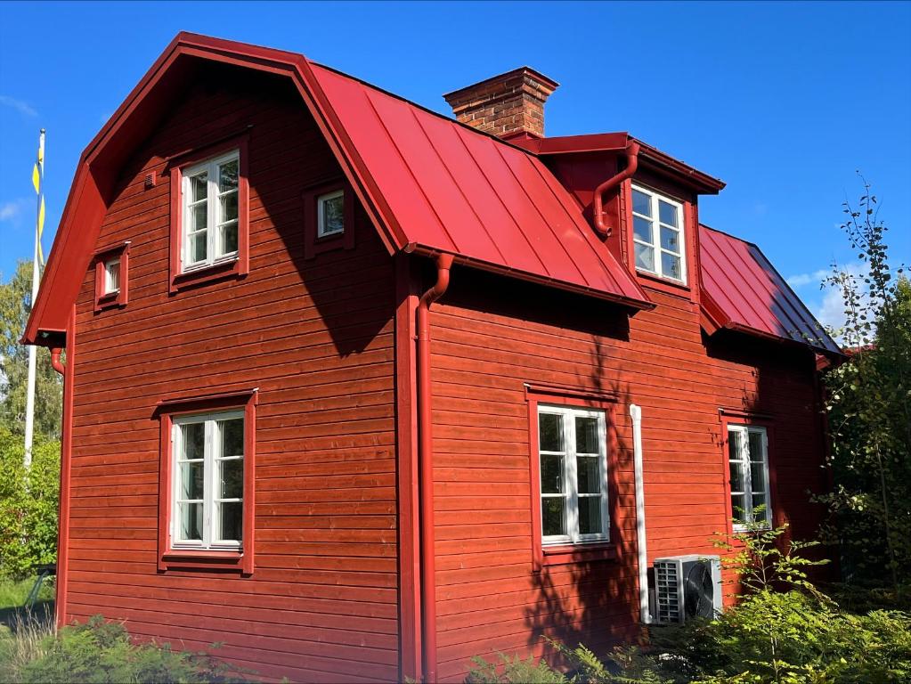 una casa roja con techo rojo en Private guesthouse close to nature and the sea en Vaxholm