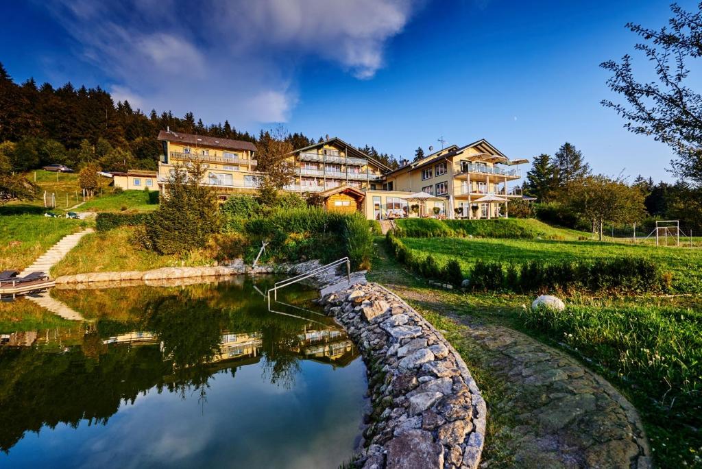 a house on a hill next to a river at Naturhotel Rebling in Bernried