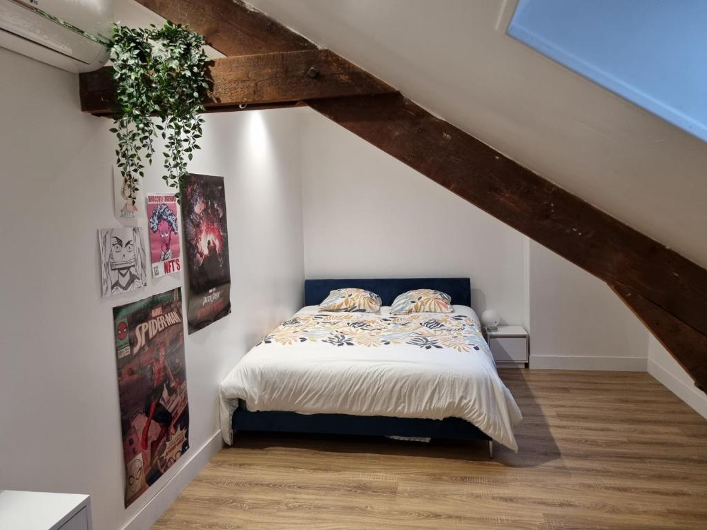a bedroom with a bed in a attic at Maison de charme - accès autonome in Orléans