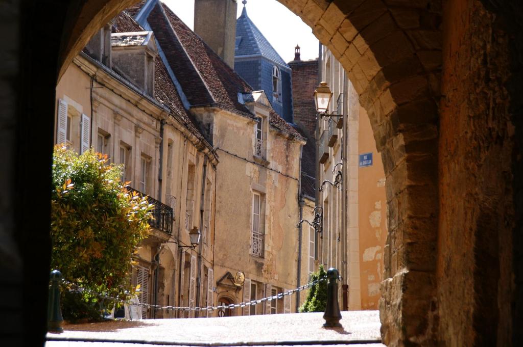 un vicolo con un arco in una città con edifici di Le Clos Saint-Sauveur a Bellême