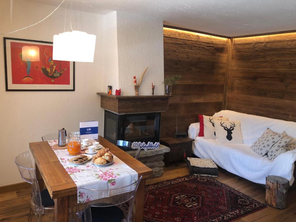 sala de estar con mesa y chimenea en House Edelweiss by Holiday World en La Thuile
