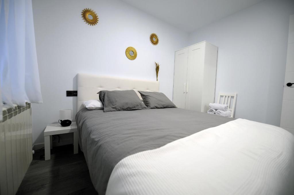 a white bedroom with a bed and a white cabinet at APARTAMENTOS LUDOVICO in Béjar