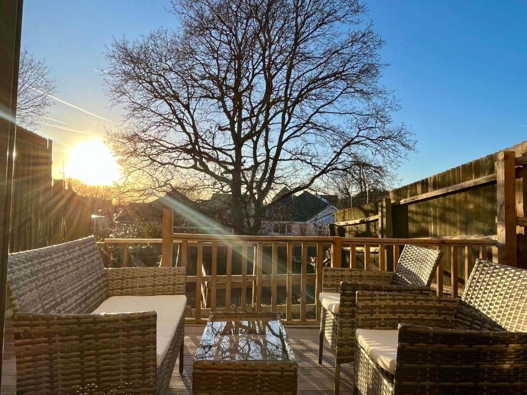 una terraza con sillas, una mesa y el sol en Oakview en Colchester