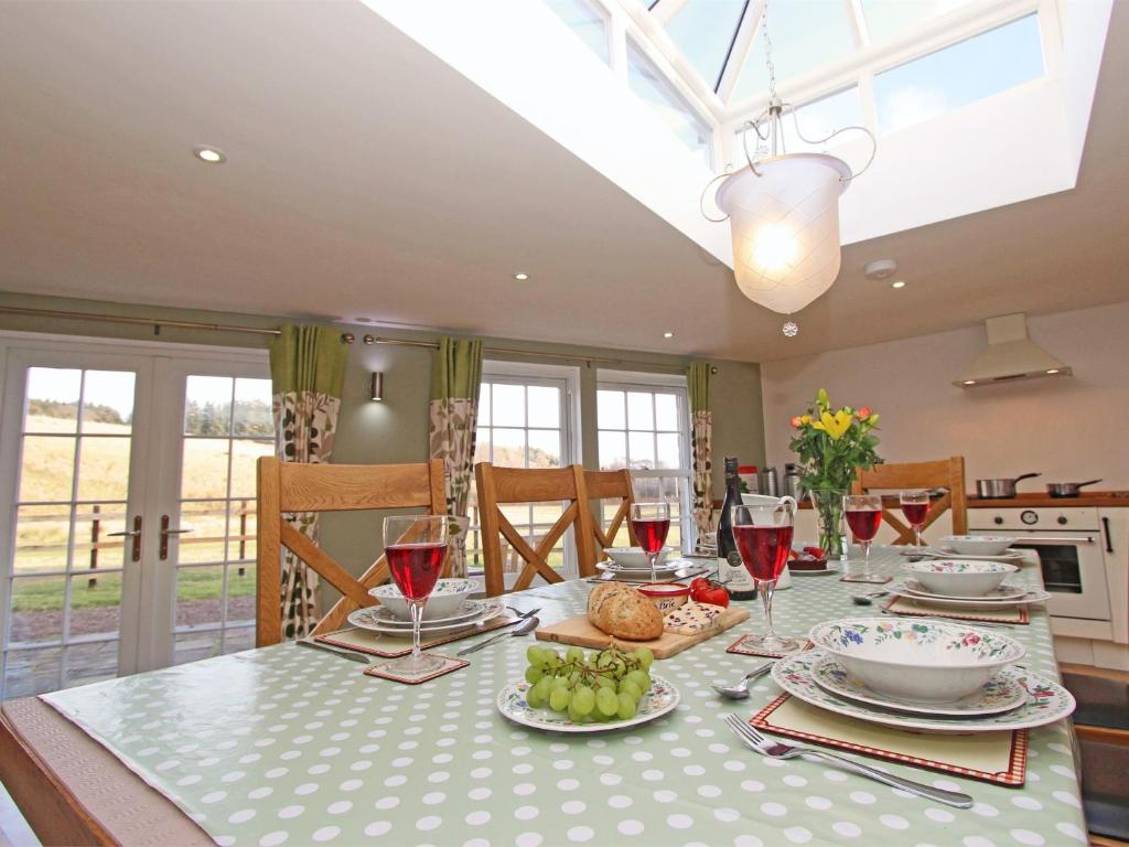 a dining room with a table with food and wine glasses at 3 Bed in Northumberland National Park CN043 in Alwinton