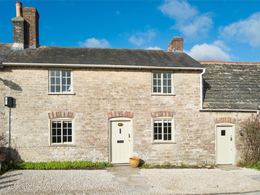 an old stone house with two white doors at 4 Bed in Isle of Purbeck IC177 in Corfe Castle