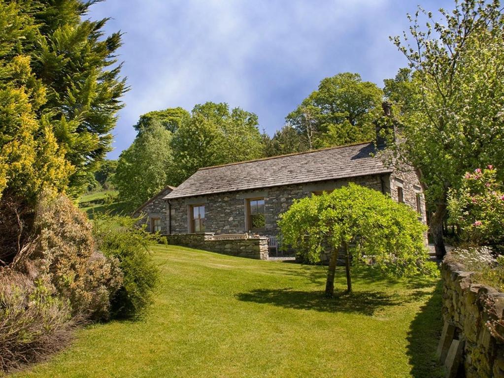 an old stone house with a garden and trees at 1 Bed in Coniston LCC50 in Coniston