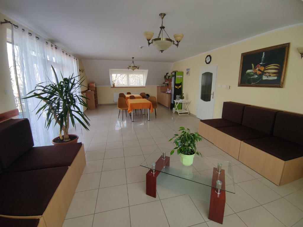 a living room with couches and a dining room at Invest Vendégház in Eger
