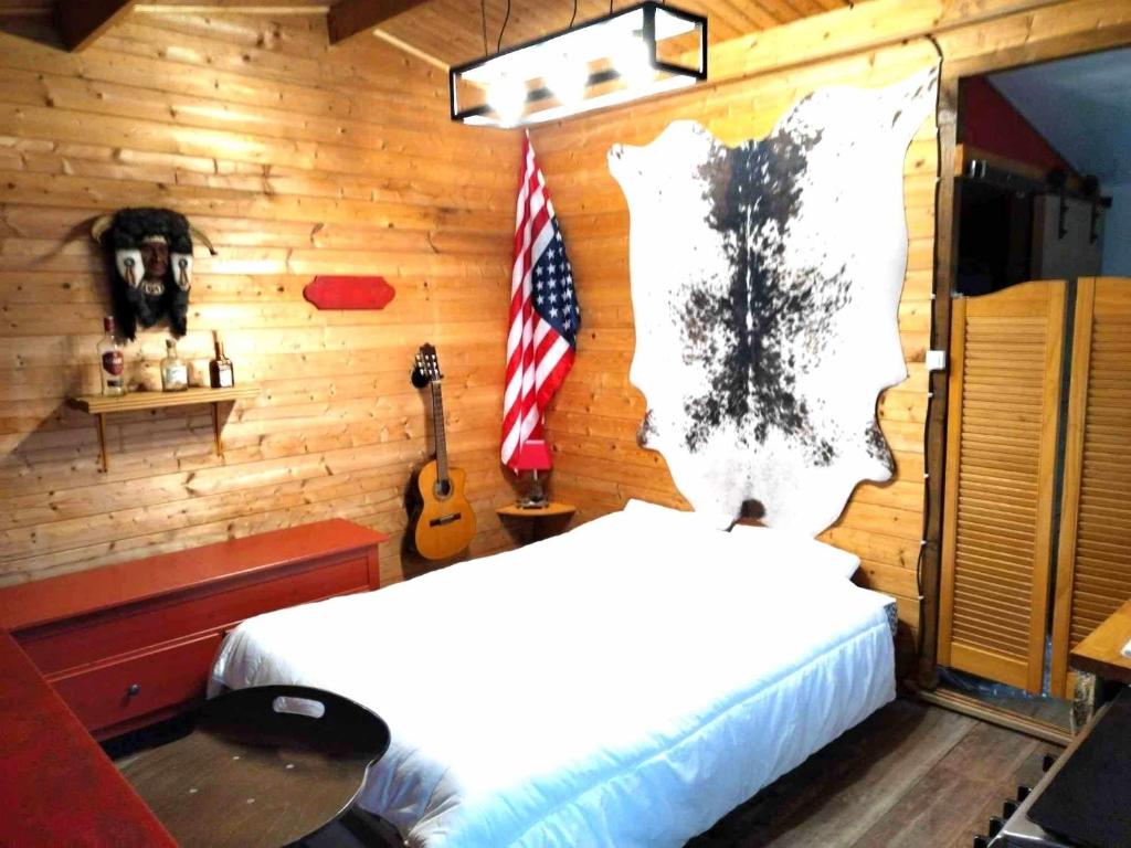ein Schlafzimmer mit einem Bett und einer Flagge an der Wand in der Unterkunft Chalet Opale Texas in Hermelinghen