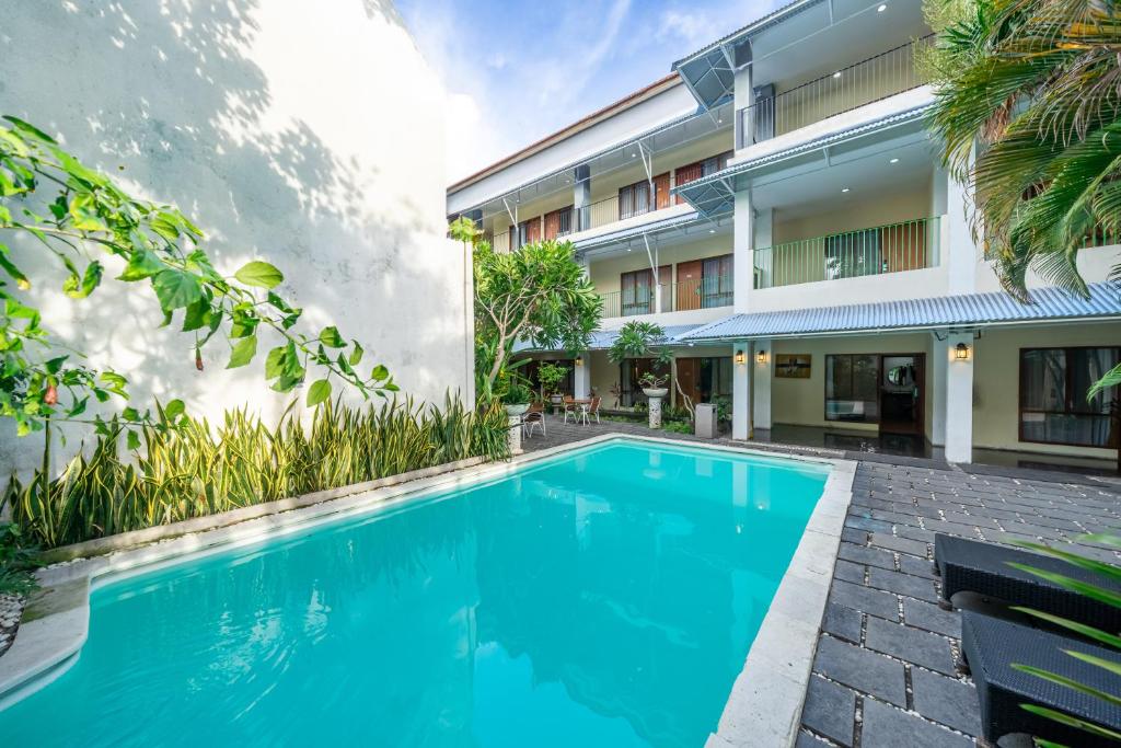 an image of a swimming pool in front of a building at Spazzio Bali Hotel in Legian