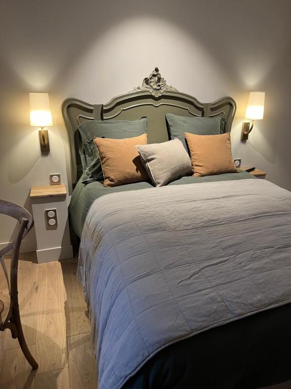 una camera da letto con un grande letto con cuscini sopra di Maison Baudry Bethune - Bedroom a Béthune
