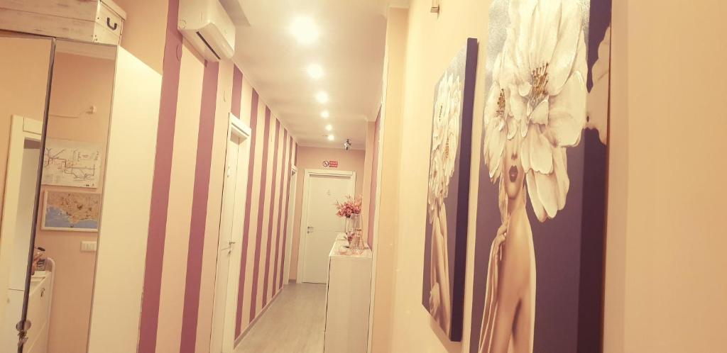 a hallway with paintings of a woman on the wall at F.Rooms Napoli in Naples