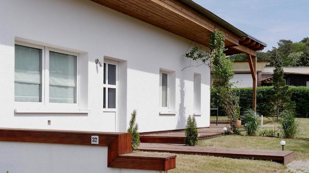 ein weißes Haus mit einer Veranda und einem Fenster in der Unterkunft Bungalow Wallner in Basedow