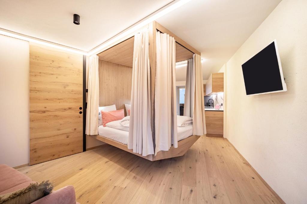 una piccola camera con un letto in una stanza di Avia Living Anna a Brunico