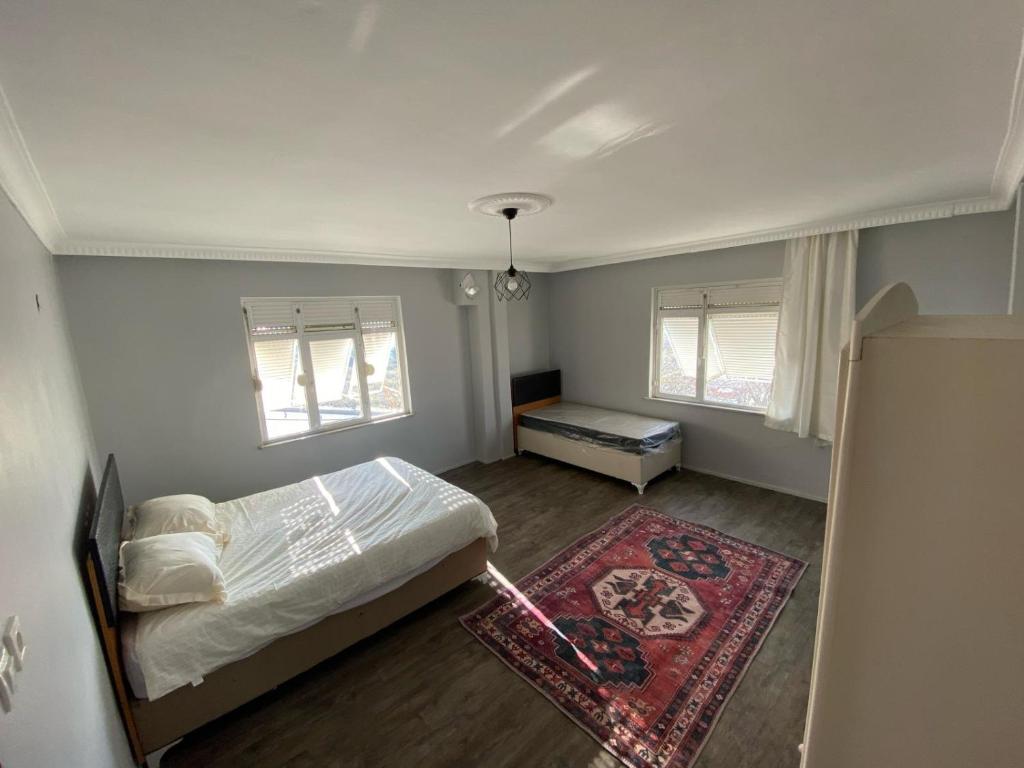 een kleine slaapkamer met een bed en een tapijt bij Triplex house 2 in Arnavutköy