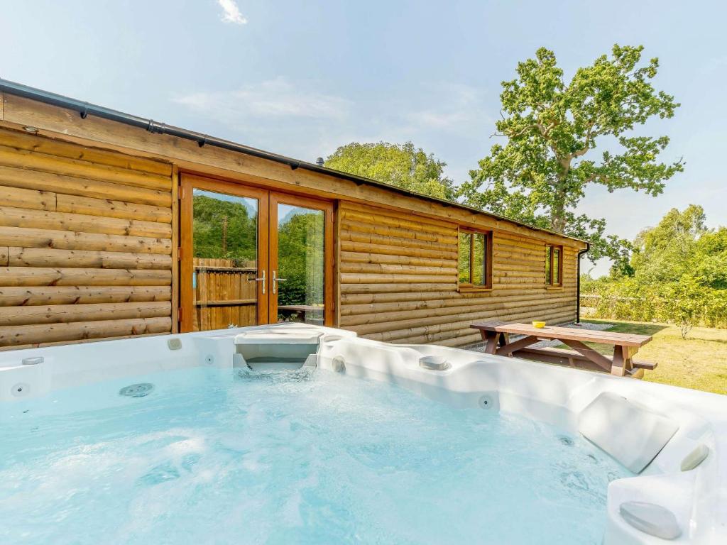 a hot tub in front of a log cabin at 2 Bed in Stanton-by-Bridge 78581 