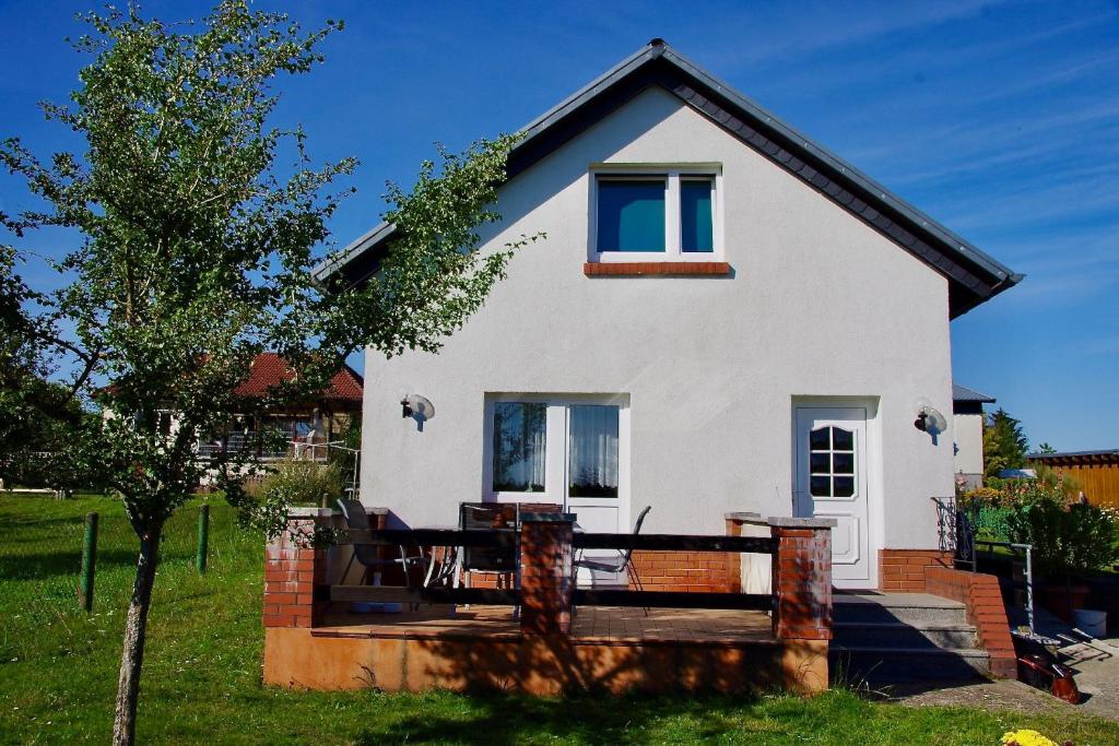 Ferienhaus "Urlaub in Mecklenburg" في Grabowhöfe: بيت ابيض مع شرفه وشجر