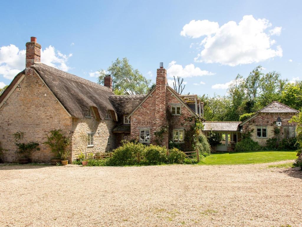 an old stone house with a thatched roof at 5 Bed in Sturminster Newton 76458 in Lydlinch