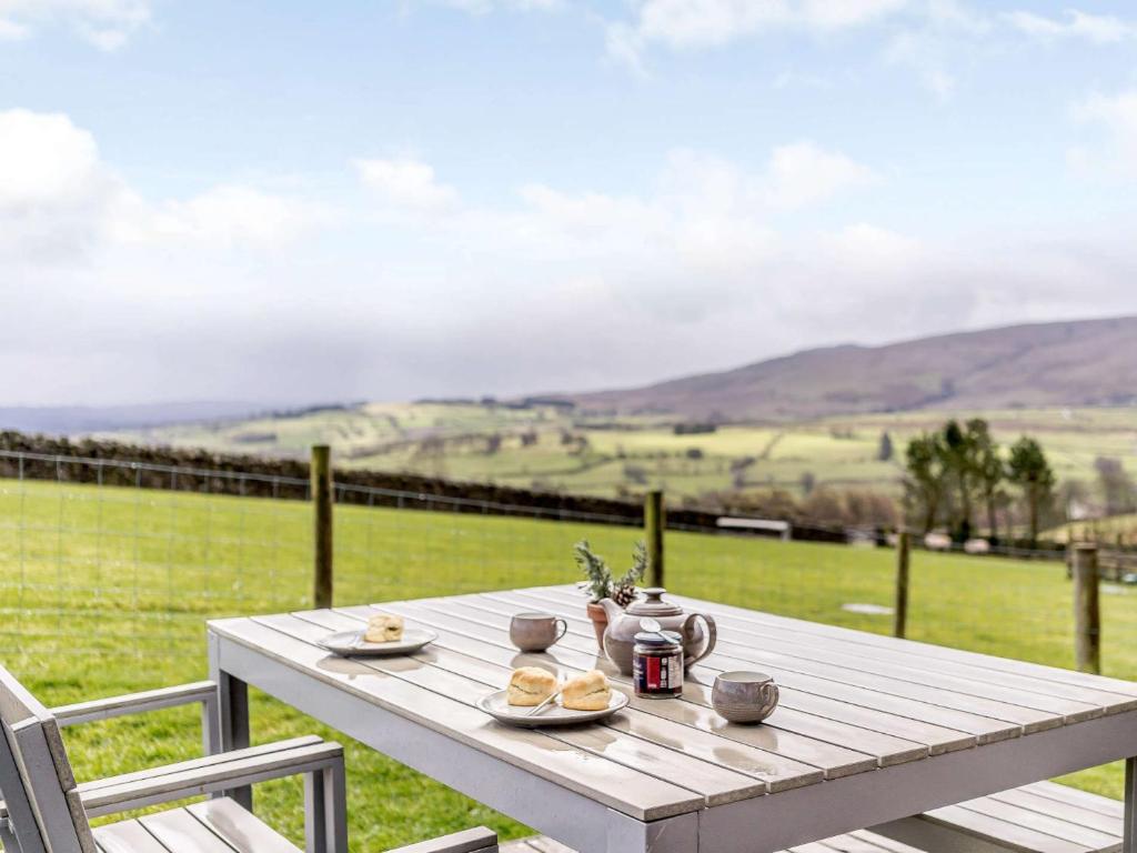 a wooden table with food on top of a field at 2 Bed in Caldbeck 80562 in Caldbeck