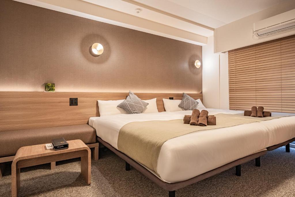 大阪市にある住一心斋橋店のベッド2台とテーブルが備わるホテルルームです。