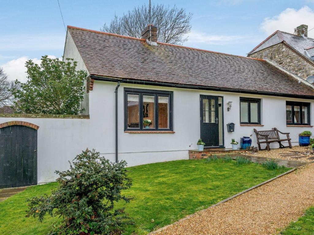 une maison blanche avec un banc dans la cour dans l'établissement 2 Bed in Lulworth Cove DC170, à West Lulworth