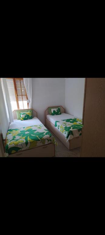 two beds in a room with a window at Akçay Kordon'da denize 40 metre in Akçay