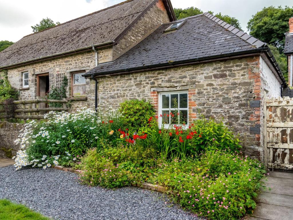 una casa in pietra con dei fiori davanti di 1 Bed in Brecon BN091 a Lower Chapel