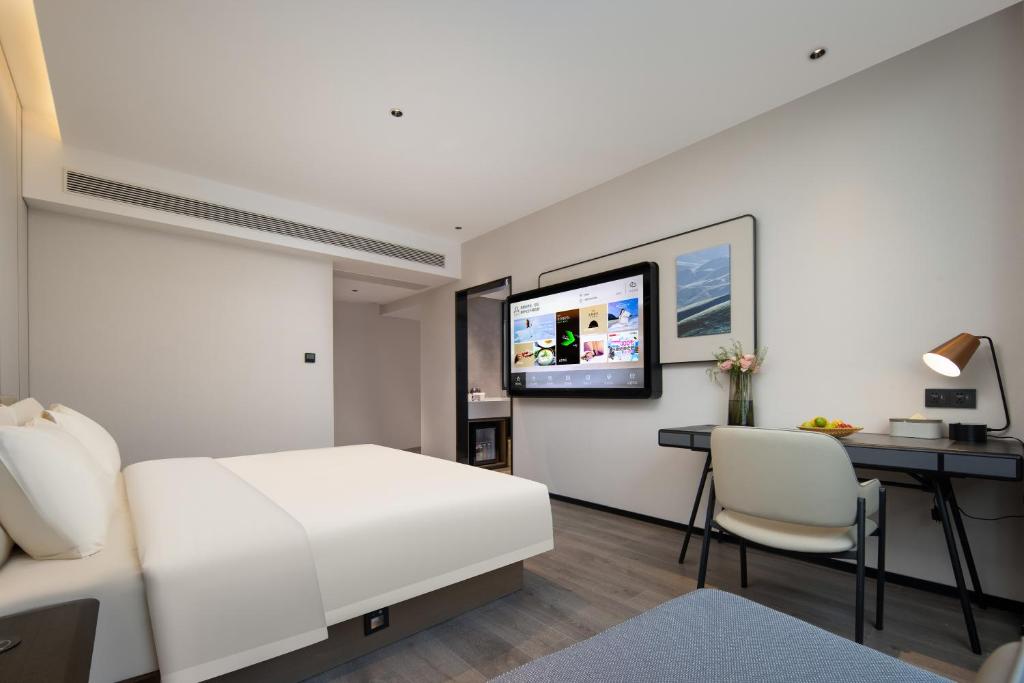 寧海的住宿－宁波宁海亚朵酒店，一间卧室配有一张床、一张书桌和一台电视。