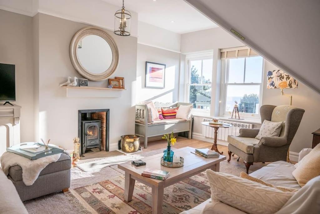 a living room with a couch and a fireplace at Gulls' Nest, Felixstowe in Felixstowe