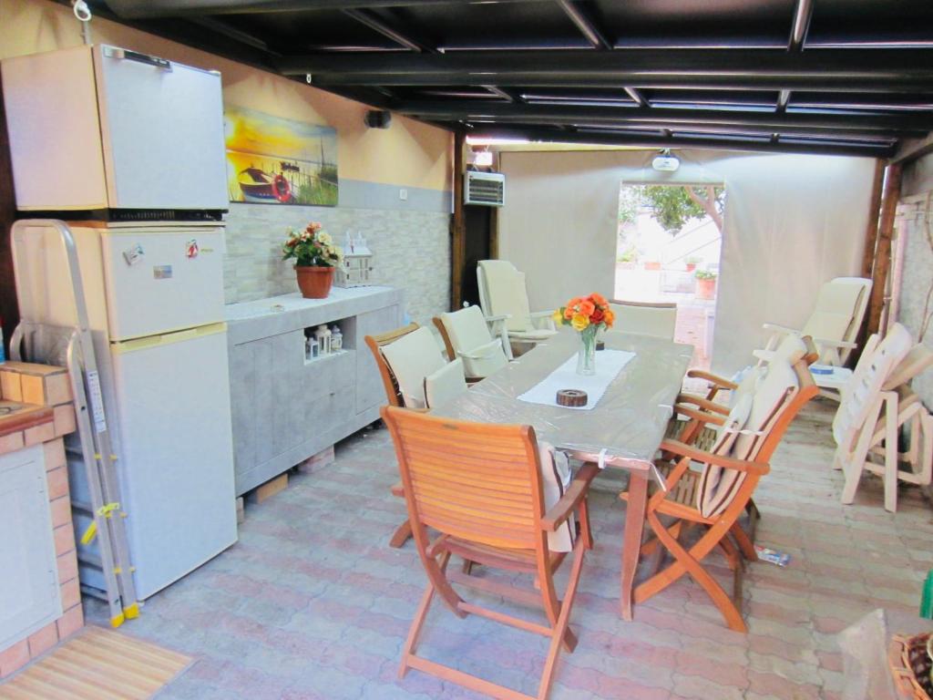 eine Küche mit einem Tisch und Stühlen sowie einem Kühlschrank in der Unterkunft Ferdirisa Vesuvio Home&Garden in San Giorgio a Cremano