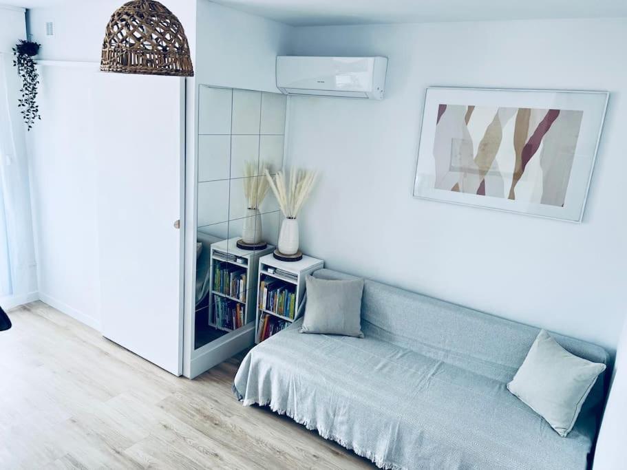 ein Wohnzimmer mit Sofa und Bücherregal in der Unterkunft ROMY Studio à 5 min de la plage in Canet-en-Roussillon