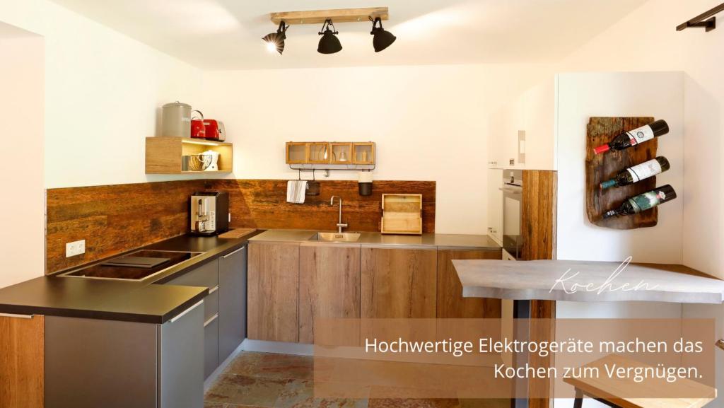 - une cuisine avec des placards en bois et un comptoir dans l'établissement Eichen-Chalet, à Winkl