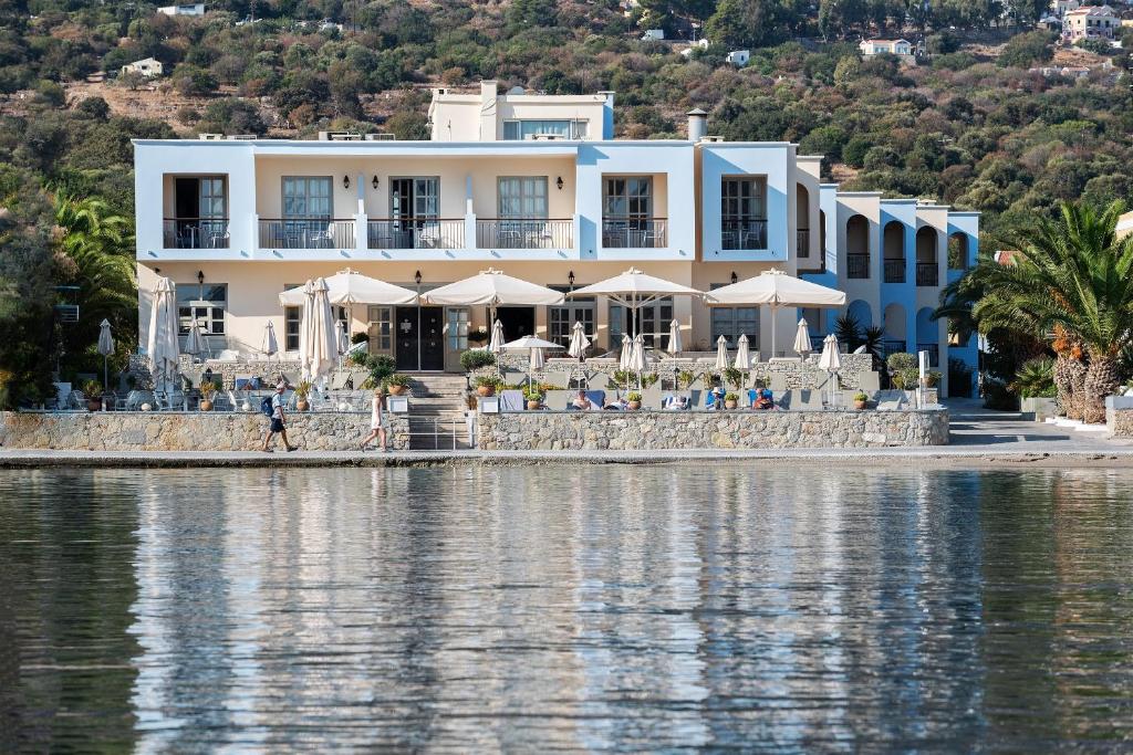 a hotel on the shore of a body of water at Pedi Beach Hotel in Symi