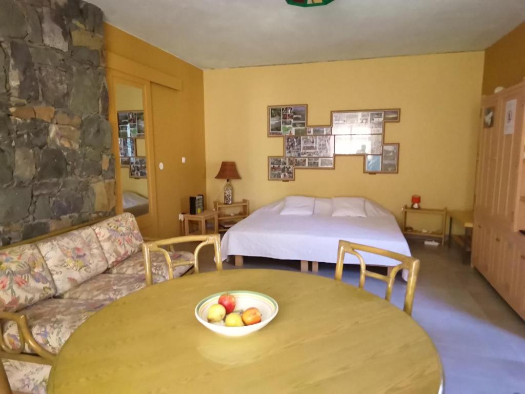 a room with a bed and a table with a bowl of fruit at Chambre indépendante in Porto Novo
