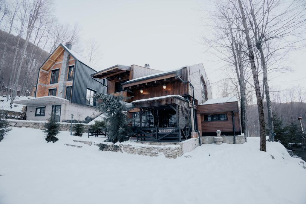 a large house in the snow with snow covered ground at SpringChillVillaBrezovica in Prevalla