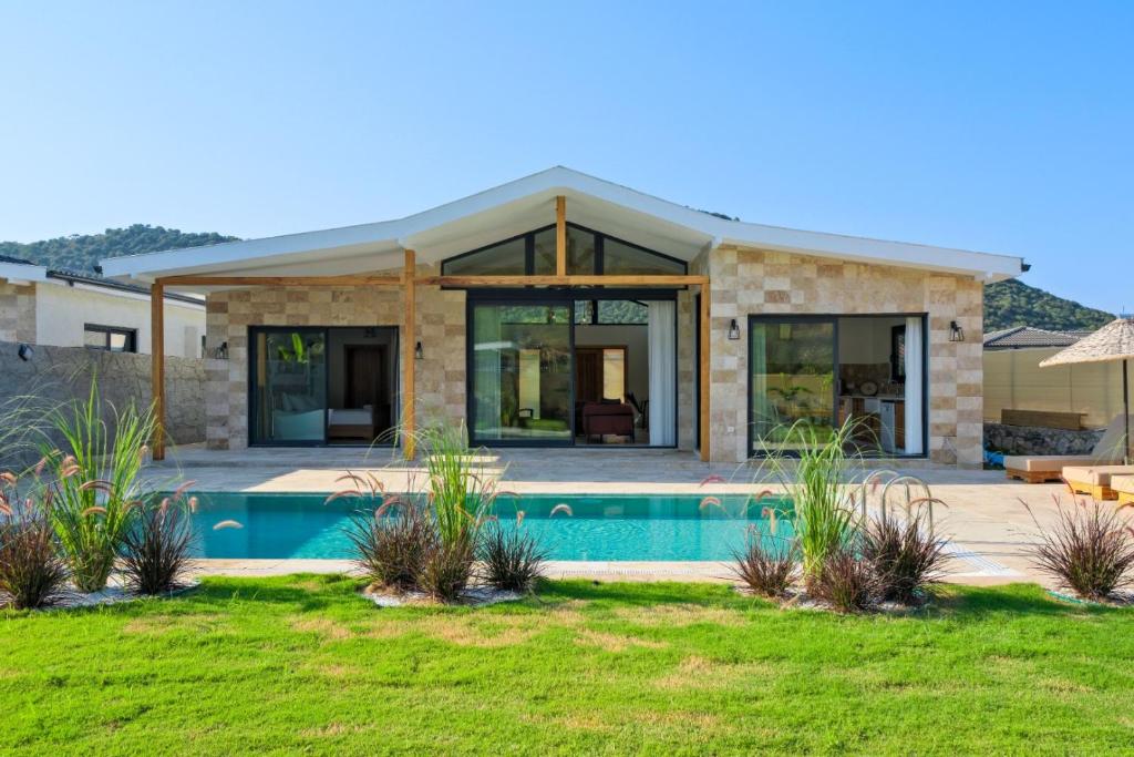 une maison avec une piscine en face de celle-ci dans l'établissement Villa Cesur, à Fethiye
