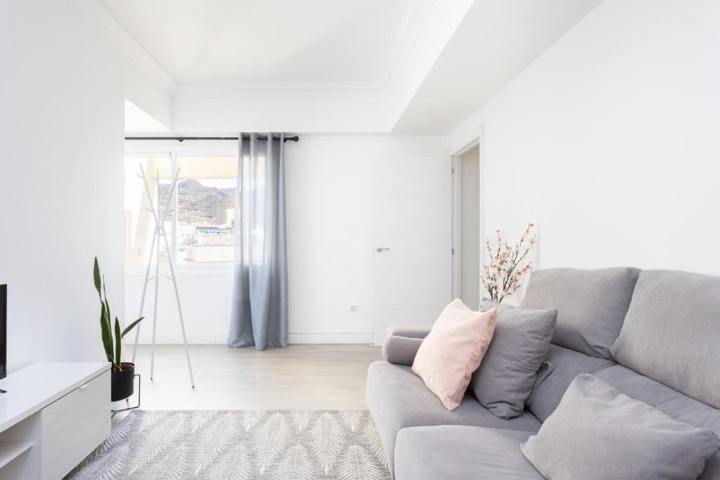 ein weißes Wohnzimmer mit einem grauen Sofa in der Unterkunft Home2Book Stylish & Bright Apt, Santa Cruz Center in Santa Cruz de Tenerife