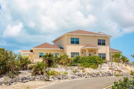 a house on top of a hill with a street at Charming Guest House near Chalk Sound and the Beach in Providenciales