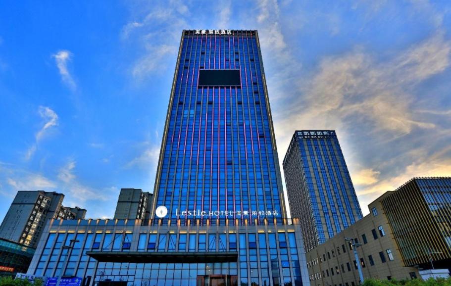 un grand bâtiment bleu avec une horloge dessus dans l'établissement Mehood Lestie, Nantong Tongzhou New Century Avenue, à Nantong
