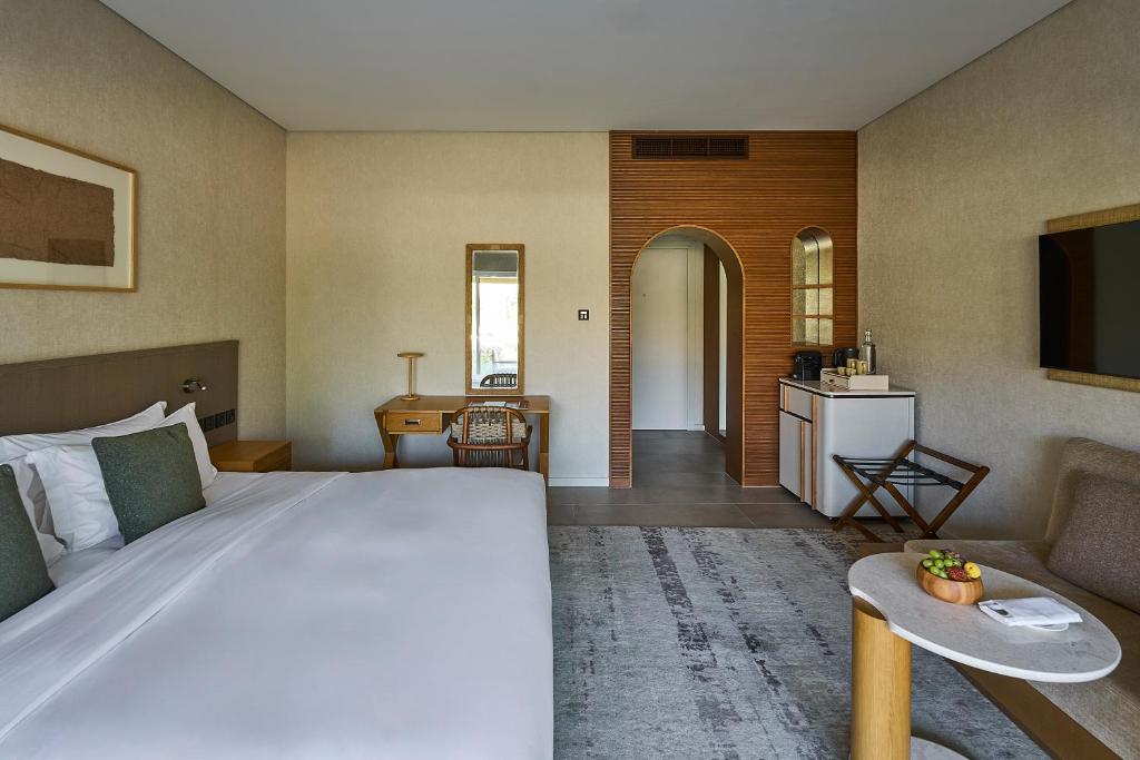 a hotel room with a large bed and a desk at ERTH Abu Dhabi Hotel in Abu Dhabi