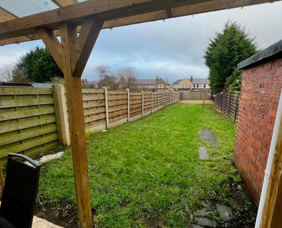 a backyard with a fence and a grass yard at 3 Bedroom House in York