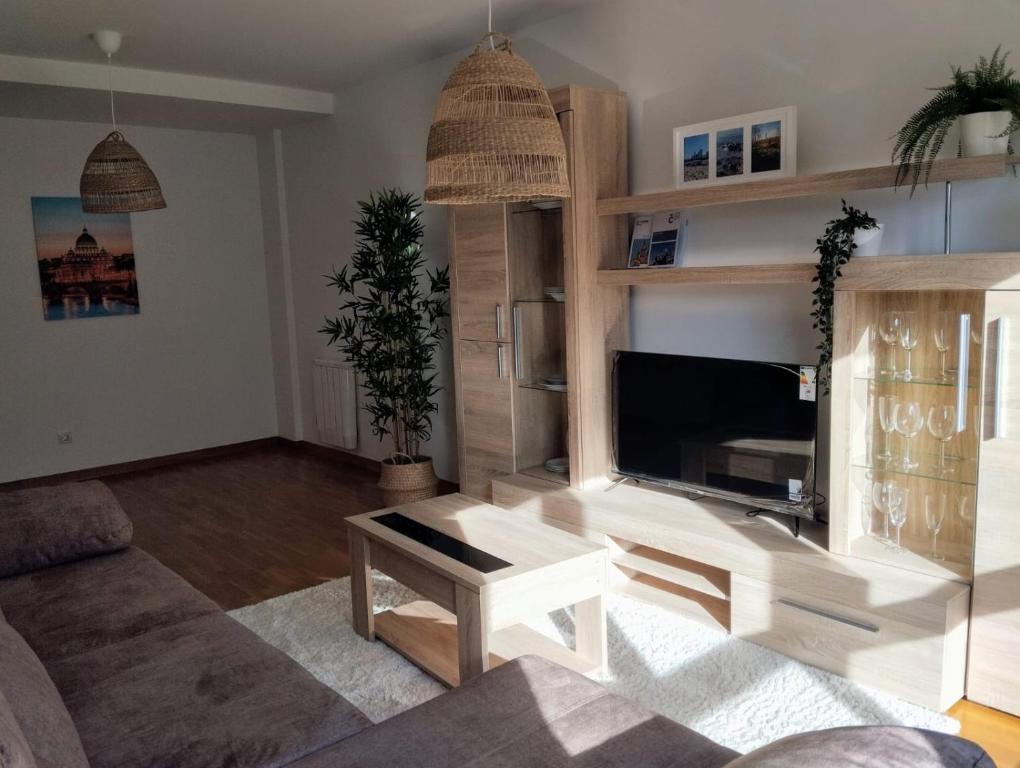 ein Wohnzimmer mit einem Sofa und einem TV in der Unterkunft Piso vacacional acogedor in A Coruña