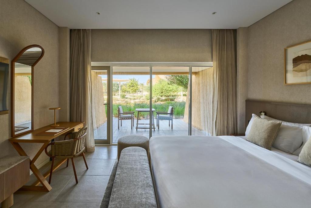 a bedroom with a bed and a desk and a table at ERTH Abu Dhabi Hotel in Abu Dhabi