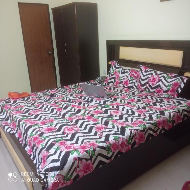 a bed with a black and white comforter on it at 2 bhk dream resort porvorim in Old Goa