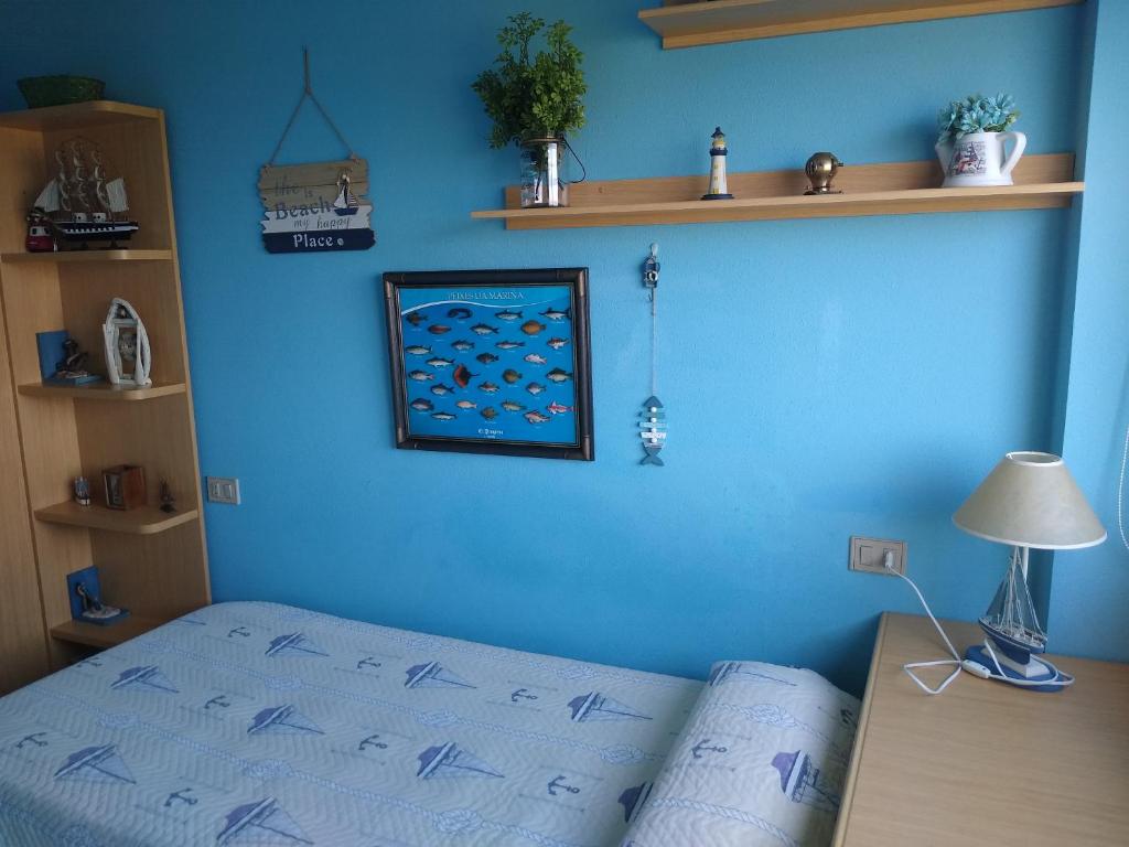 フォスにあるApartamento en Foz Entreplayasの青い壁のベッドルーム(ベッド付)
