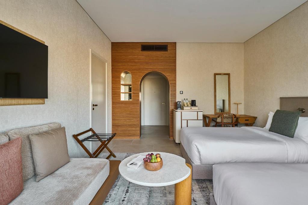 a hotel room with two beds and a living room at ERTH Abu Dhabi Hotel in Abu Dhabi