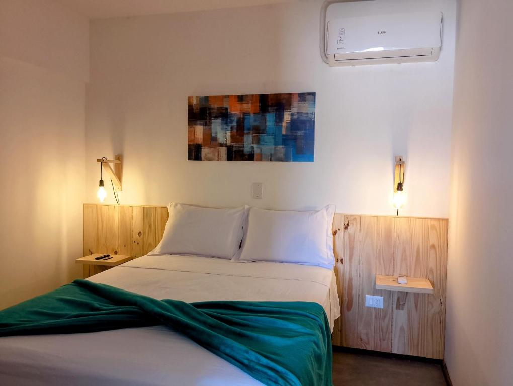 a bedroom with a white bed with two lights on at Apartamento Casal beira mar, Ventos de Sibaúma in Tibau do Sul