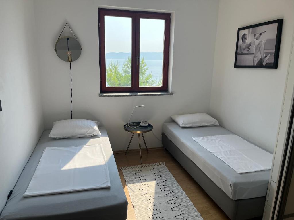 2 camas en una habitación con ventana en Sara Brela Apartment en Brela