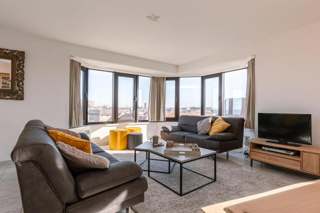 - un salon avec deux canapés et une télévision dans l'établissement Spacious & modern sea view apartment with garage, à Ostende