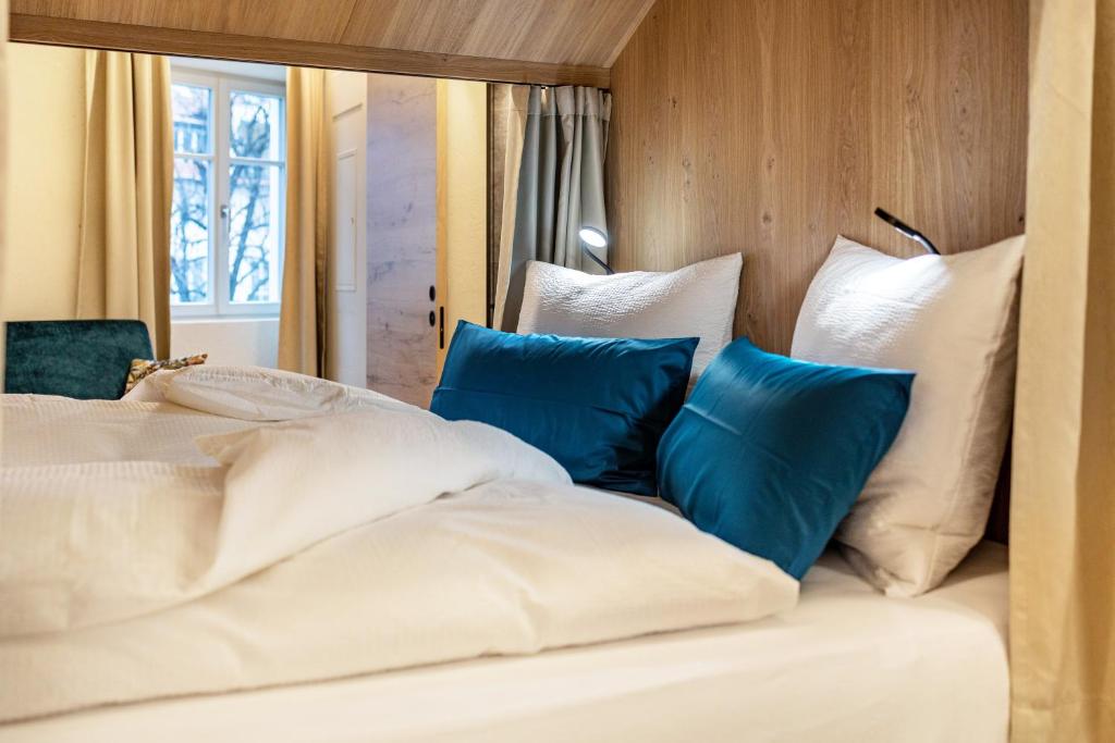 ein Bett mit weißen und blauen Kissen darauf in der Unterkunft Avia Living Elisabeth in Bruneck